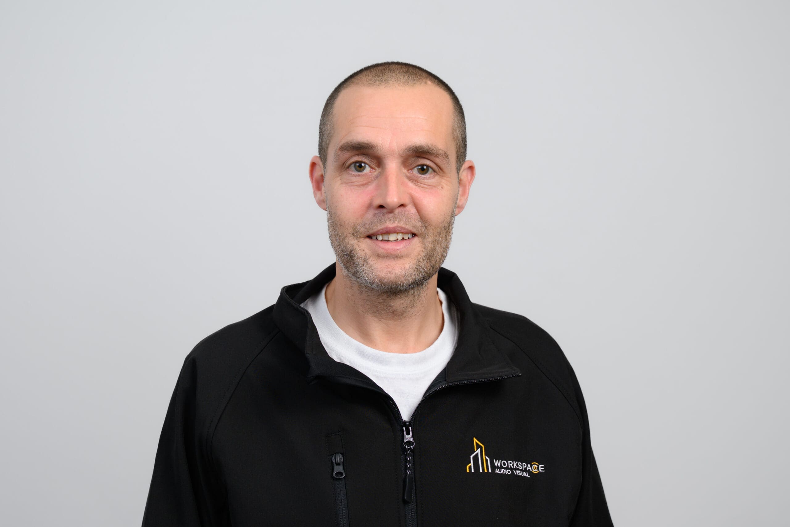 man in a black jacket is posing for a picture