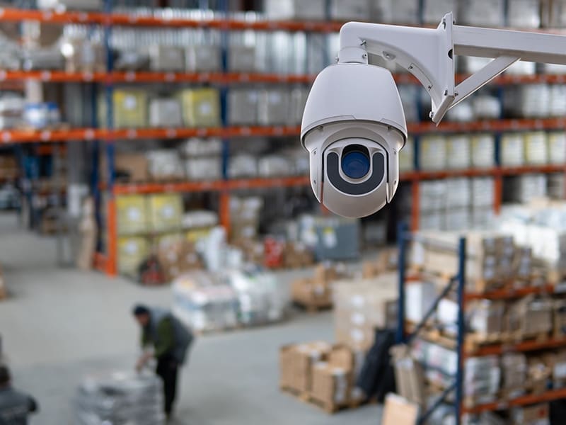 security camera hanging from a ceiling in a warehouse